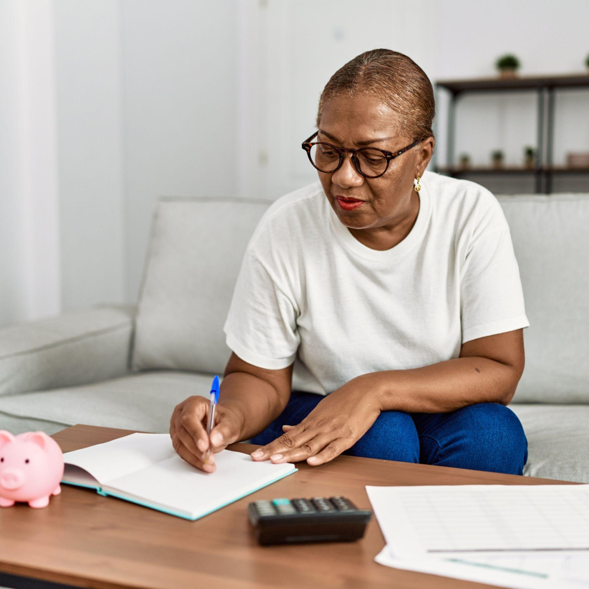 A lady creating her personal budget using pen and paper system 