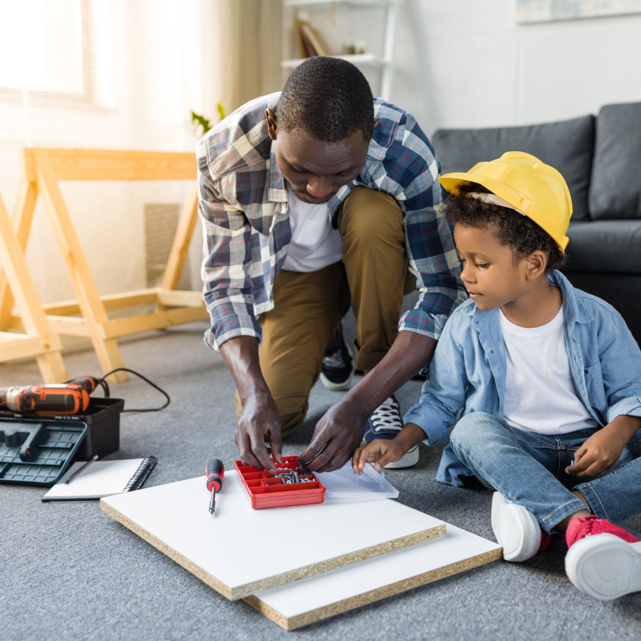 Father helping his son build a desk to save money.