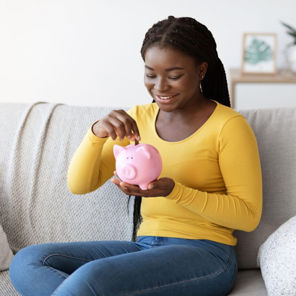 Lady saving money in a piggy bank at home